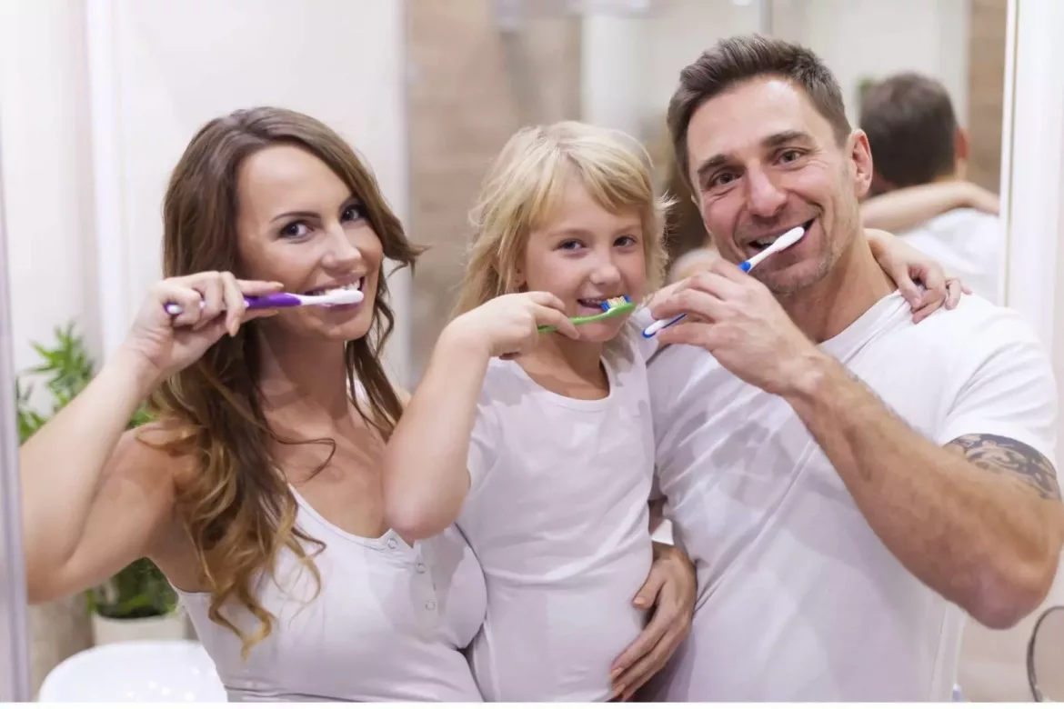 Rodzina myje zęby ucząc dziecko mycia zębów mlecznych